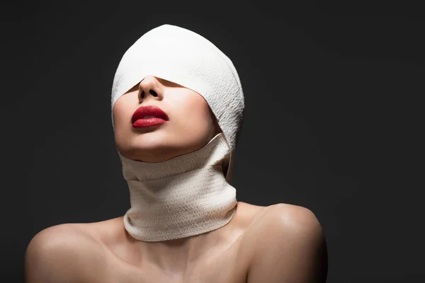 Femme en bandage élastique avec épaules nues posant isolé sur noir — Photo de stock