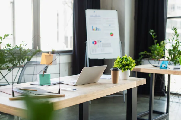 Laptop in der Nähe von Coffee to go und Papiere im Büro — Stockfoto