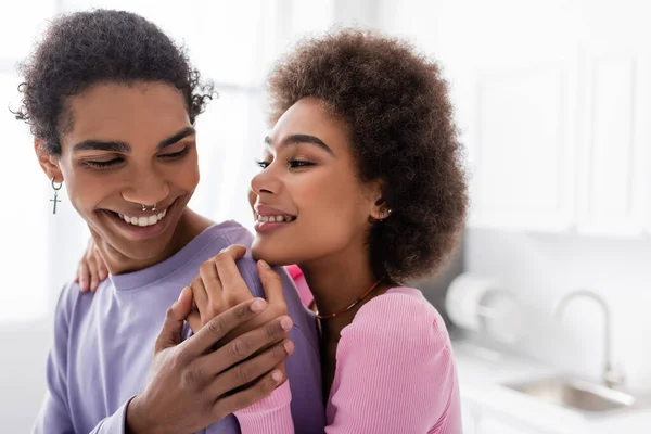 Positivo afroamericano hombre tocando mano de novia en casa - foto de stock