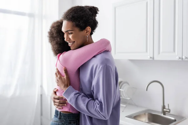 Jovem afro-americano homem abraçando namorada em casa — Fotografia de Stock