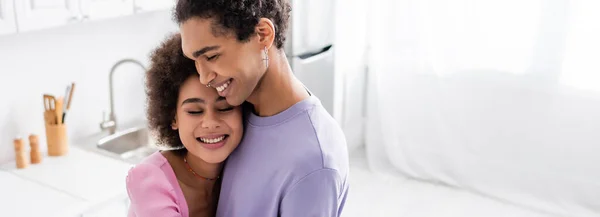 Jeune femme afro-américaine debout près de petit ami dans la cuisine, bannière — Photo de stock