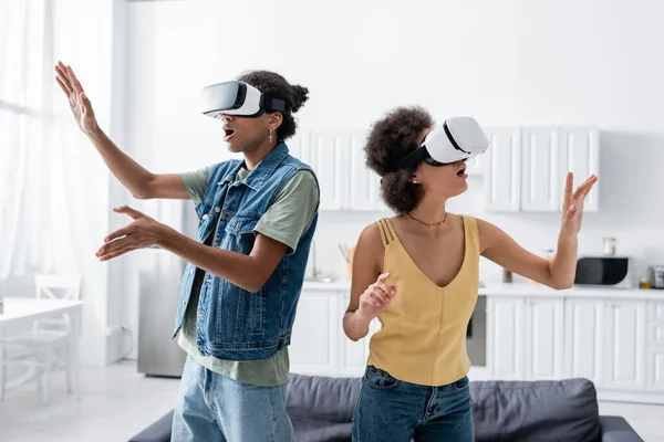 Shocked african american couple in vr headsets standing at home — Stock Photo