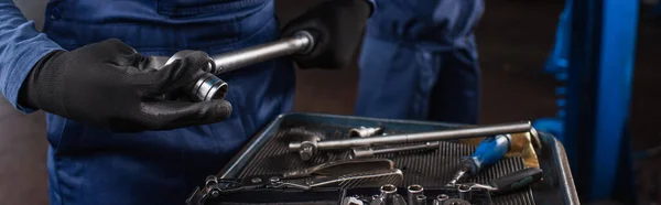 Ausgeschnittene Ansicht des Mechanikers in Uniform und Handschuhen mit Schraubenschlüssel im Autoservice, Banner — Stockfoto