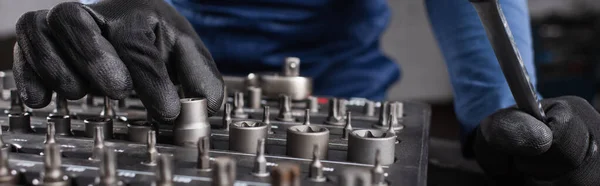 Ausgeschnittene Ansicht des Mechanikers in Handschuhen mit Werkzeug in der Garage, Banner — Stockfoto