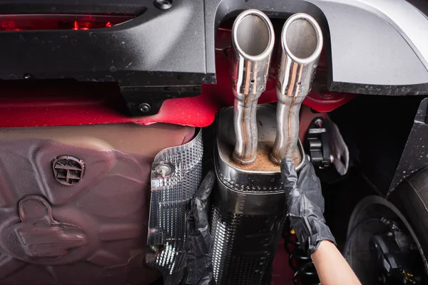 Cropped view of workwoman in glove working with vehicle silencer in service — Stock Photo