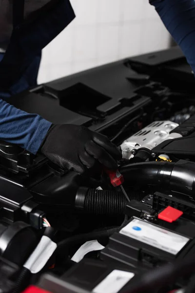 Partial view of mechanic fixing car engine with screwdriver — Stock Photo