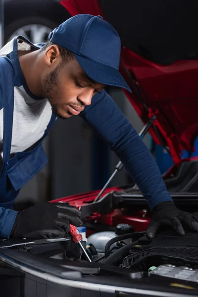 African american foreman with screwdriver making diagnostics of car engine — Fotografia de Stock