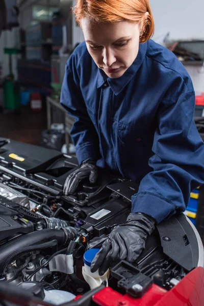 Mécanicien en gants de travail inspectant compartiment moteur de l'automobile en service de voiture — Photo de stock