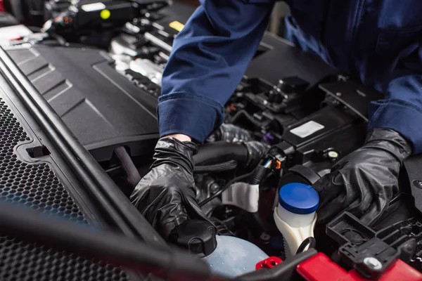 Zugeschnittene Ansicht des Mechanikers in Arbeitshandschuhen Befestigung Motor des Autos — Stockfoto