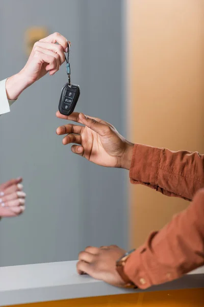 Partial view of african american man taking key from car dealer — Fotografia de Stock