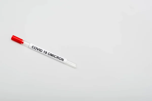 Top view of covid-19 omicron test tube on grey background with copy space — Stock Photo