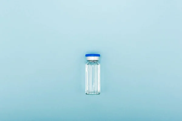 Top view of vaccine bottle on blue background, omicron variant concept — Fotografia de Stock