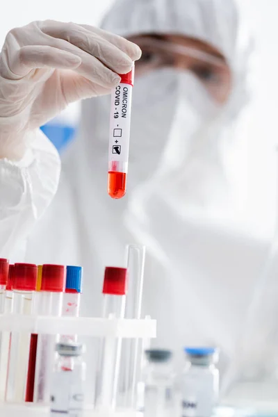 Blurred scientist holding positive covid-19 omicron test while working in laboratory — Stock Photo
