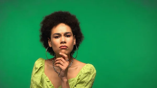 Pensive african american woman looking at camera isolated on green — Fotografia de Stock