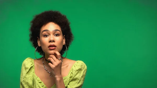 Pensive african american woman looking at camera isolated on green — Stockfoto