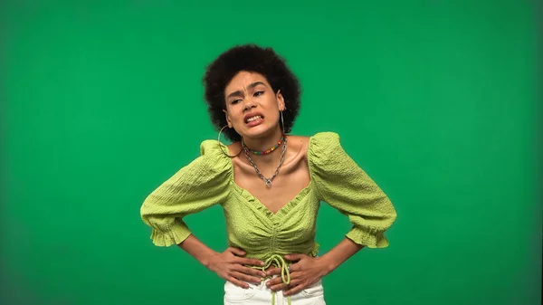 Disgustado mujer afroamericana sentirse mal mientras tiene dolor de estómago aislado en verde - foto de stock
