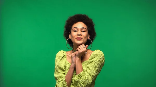 Happy african american woman in blouse and hoop earrings isolated on green — Foto stock