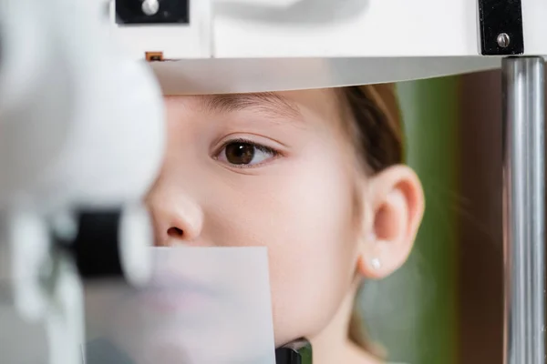 Close up view of kid examining eyesight on blurred ophthalmoscope — Fotografia de Stock