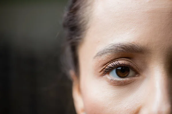 Vue partielle de la jeune femme regardant la caméra, concept de soins oculaires — Photo de stock