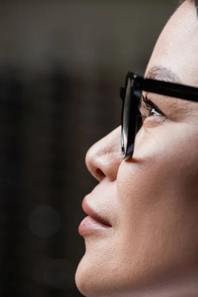 Профіль азіатської жінки, дивлячись в окуляри, концепція догляду за очима — стокове фото