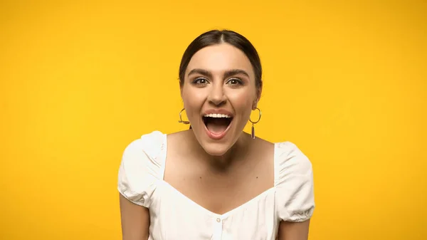 Excited woman in blouse looking at camera isolated on yellow — стоковое фото