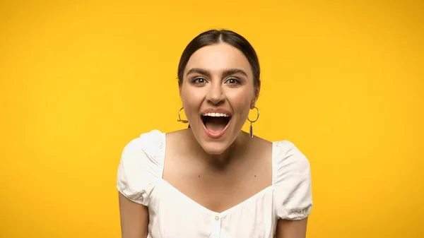 Mujer excitada en blusa mirando la cámara aislada en amarillo - foto de stock