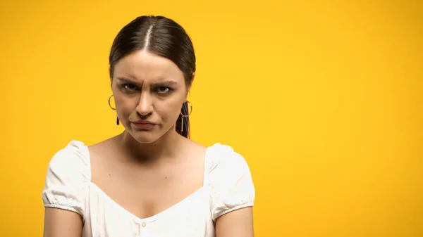 Angry brunette woman in blouse looking at camera isolated on yellow — Stock Photo