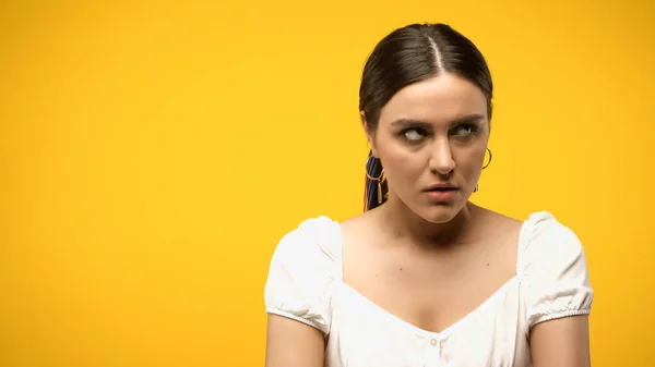 Irritated brunette woman looking away isolated on yellow — Stock Photo