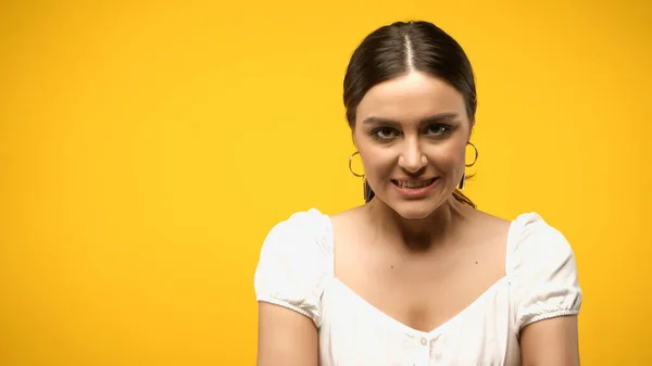 Mujer agresiva en blusa mirando la cámara aislada en amarillo - foto de stock