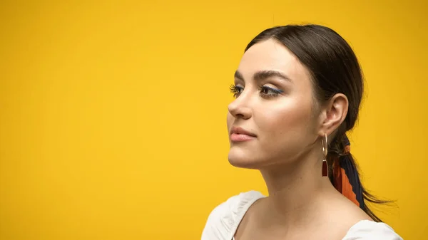 Retrato de jovem morena olhando para longe isolado no amarelo — Fotografia de Stock