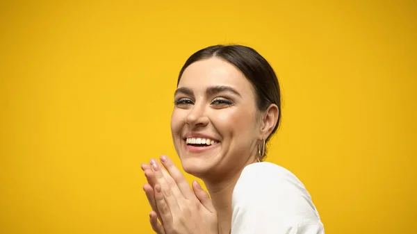 Pretty brunette woman looking at camera isolated on yellow - foto de stock