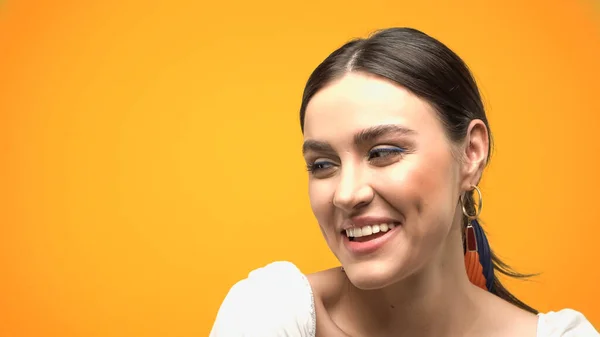 Young smiling woman looking away isolated on yellow — Stock Photo