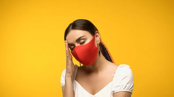 Donna stanca in maschera protettiva in piedi isolata sul giallo — Foto stock