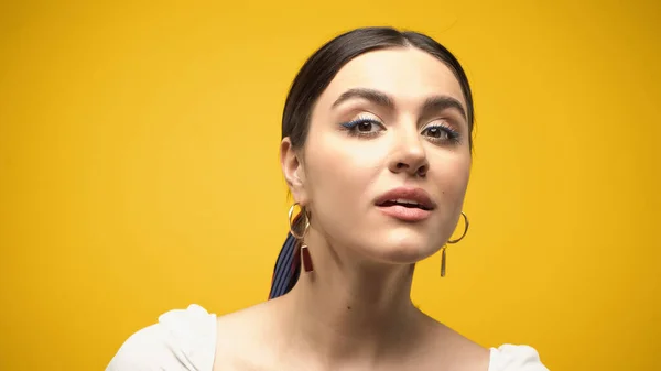 Brunette model looking at camera isolated on yellow — Stockfoto