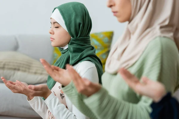 Preteen criança no hijab orando perto dos pais em casa — Fotografia de Stock