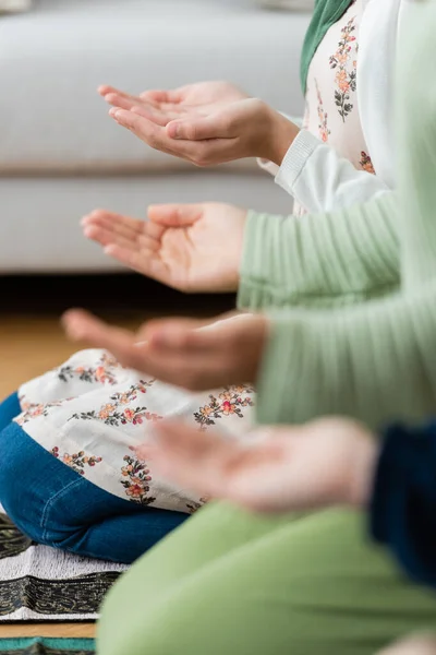 Ausgeschnittene Ansicht verschwommener arabischer Frauen und betender Kinder zu Hause — Stockfoto