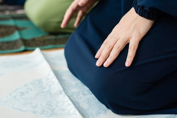 Ausgeschnittene Ansicht einer Frau, die zu Hause auf Teppich sitzt — Stockfoto