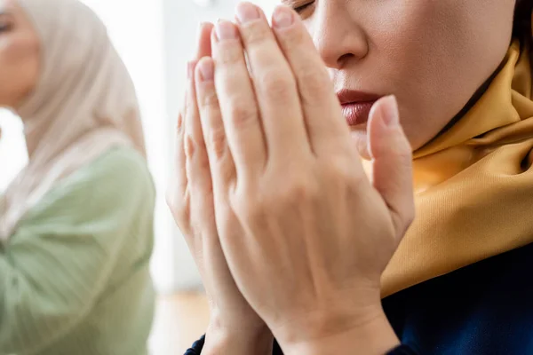 Cropped view of asian woman praying near daughter at home — Stock Photo