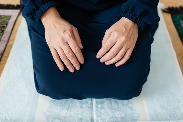 Vue recadrée de la femme arabe assise sur un tapis avec ornement — Photo de stock