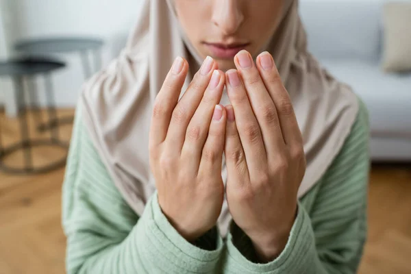 Обрізаний вид розмитої мусульманської жінки, що молиться вдома — стокове фото