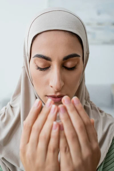 Portrait of young arabian woman praying with closed eyes — Stock Photo