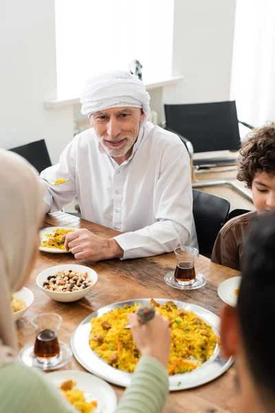 Arabe garçon ayant dîner en famille avec grand-père musulman et parents flous — Photo de stock