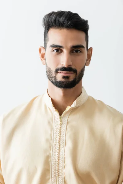 Young bearded muslim man in traditional clothes looking at camera isolated on white — Stock Photo