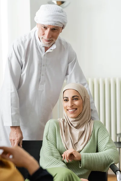 Mature muslim man standing near happy arabian daughter in hijab — Stock Photo