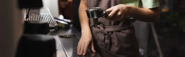 Обрізаний вид бариста, що тримає портативний фільтр біля кавоварки в кафе, банер — стокове фото