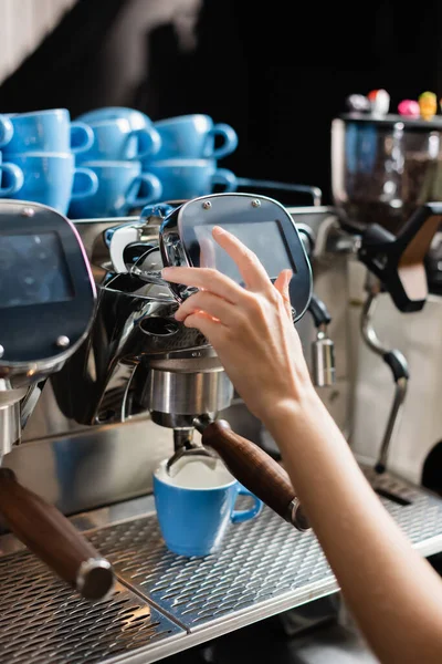 Vista recortada de barista usando máquina de café cerca de tazas en la cafetería - foto de stock