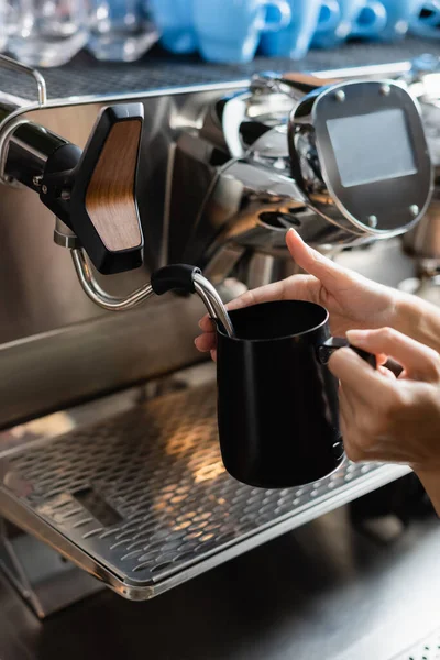 Ausgeschnittene Ansicht der Barista-Krug in der Nähe Dampfstab der Kaffeemaschine in Restaurant — Stockfoto