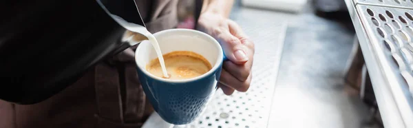 Vista recortada de barista vertiendo leche en el café en la cafetería, pancarta - foto de stock