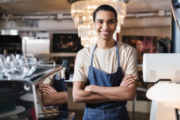 Lächelnder afrikanisch-amerikanischer Barista verschränkt die Arme im Café — Stockfoto