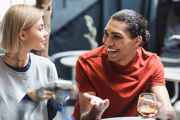 Sorridente coppia interrazziale in possesso di caffè in caffè — Foto stock